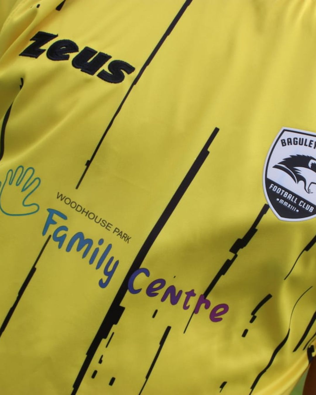 A closer look at the away shirt — the Baguley crest alongside the Woodhouse Park Family Centre logo.