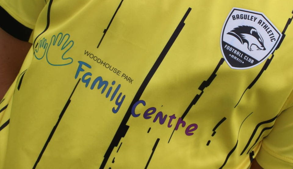 The yellow away shirt carrying the Woodhouse Park Family Centre logo beside the club crest